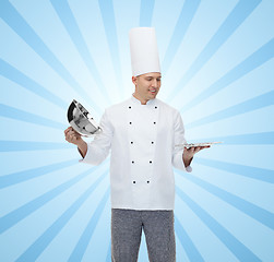 Image showing happy male chef cook opening cloche