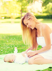 Image showing happy mother lying with little baby on blanket