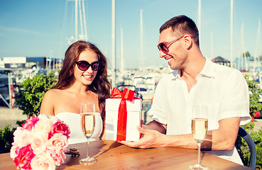 Image showing smiling couple with gift box cafe