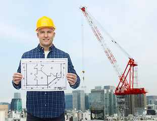 Image showing smiling male builder in helmet with blueprint