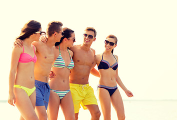 Image showing smiling friends in sunglasses on summer beach