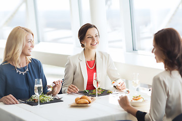 Image showing happy women eating and talking at restaurant