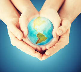 Image showing close up of woman and man hands with earth globe