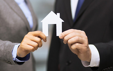 Image showing businessman and businesswoman holding white house