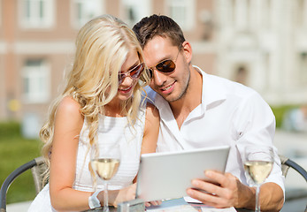 Image showing couple looking at tablet pc in cafe