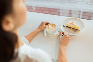 Image showing close up of woman hands with cake and coffee