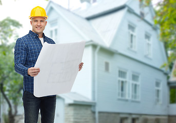 Image showing smiling builder with blueprint over house