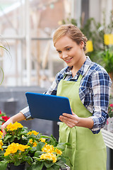 Image showing happy woman with tablet pc in greenhouse