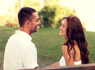 Image showing smiling couple sitting on bench in park