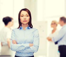 Image showing smiling businesswoman with crossed arms at office