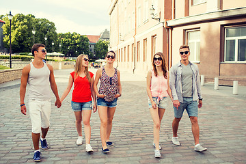 Image showing group of smiling friends walking in the city