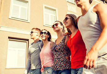 Image showing group of smiling friends walking in city