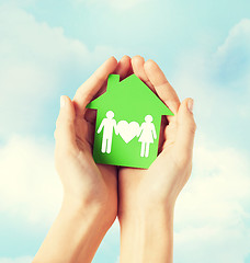 Image showing hands holding green house with family