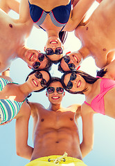 Image showing smiling friends in circle on summer beach