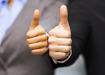 Image showing businessman and businesswoman showing thumbs up