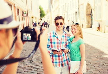 Image showing smiling couple with map and photo camera in city