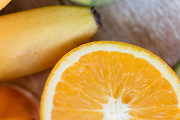 Image showing close up of fresh juicy orange and banana on table