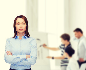 Image showing smiling businesswoman with crossed arms at office