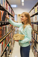 Image showing happy student girl or woman with book in library