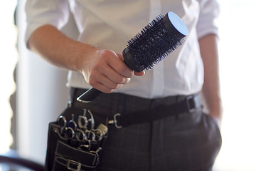 Image showing close up of male stylist with brush at salon