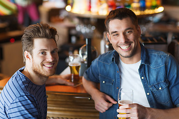 Image showing happy male friends drinking beer at bar or pub