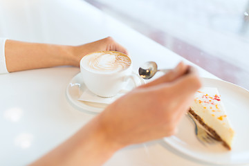 Image showing close up of woman hands with cake and coffee