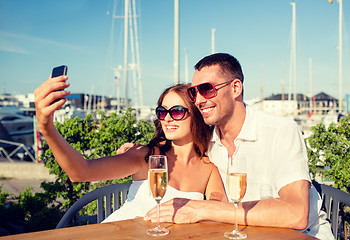 Image showing smiling couple drinking champagne at cafe