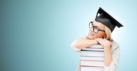 Image showing happy student in mortar board cap with books