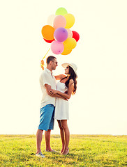 Image showing smiling couple with air balloons outdoors