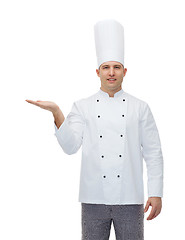 Image showing happy male chef cook showing empty palm