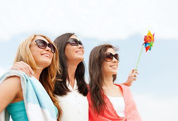 Image showing smiling girls in shades having fun on the beach