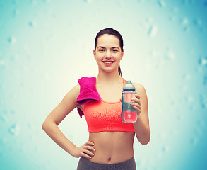 Image showing sporty woman with towel and water bottle