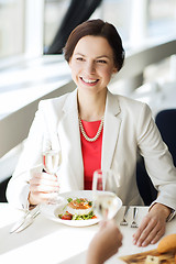 Image showing happy woman drinking champagne at restaurant