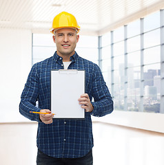 Image showing smiling male builder in helmet with clipboard