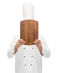 Image showing male chef cook covering face with cutting board