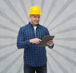 Image showing smiling male builder in helmet with tablet pc