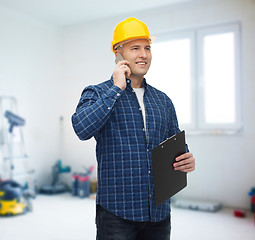 Image showing smiling male builder in helmet with clipboard