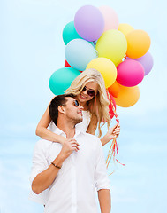 Image showing couple with colorful balloons at seaside