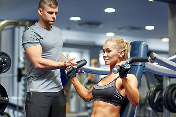 Image showing man and woman flexing muscles on gym machine