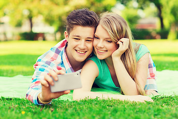 Image showing smiling couple making selfie in park