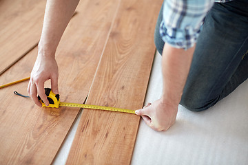 Image showing close up of male hands measuring flooring