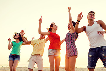 Image showing smiling friends dancing on summer beach
