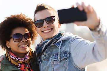 Image showing happy teenage friends in shades taking selfie