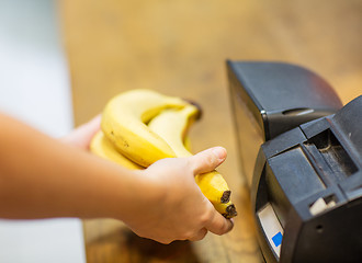 Image showing close up of hands buying bananas at checkout