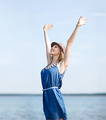 Image showing girl with hands up on the beach