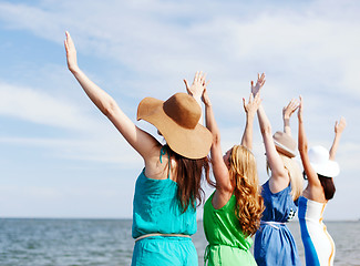 Image showing girls looking at the sea with hands up