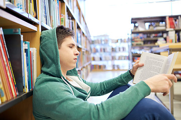 Image showing student boy or young man reading book in library