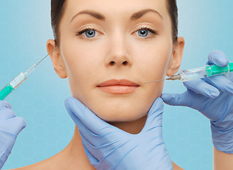 Image showing woman face and surgeon hands with syringes