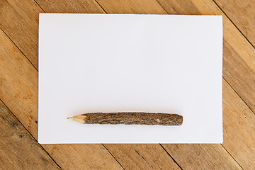 Image showing white blank paper sheet with wooden pen on table 