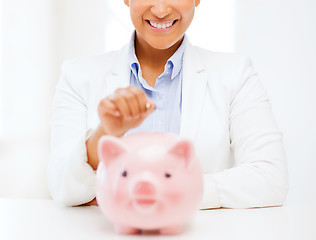 Image showing woman with piggy bank and coin